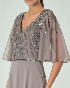 Abito lungo grigio in georgette con maniche al gomito a mantella e ricami in paillettes tono su tono