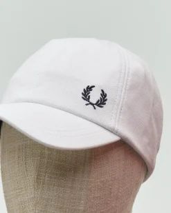 Berretto Fred Perry bianco in piquè di cotone con frontino e logo corona d'alloro ricamato