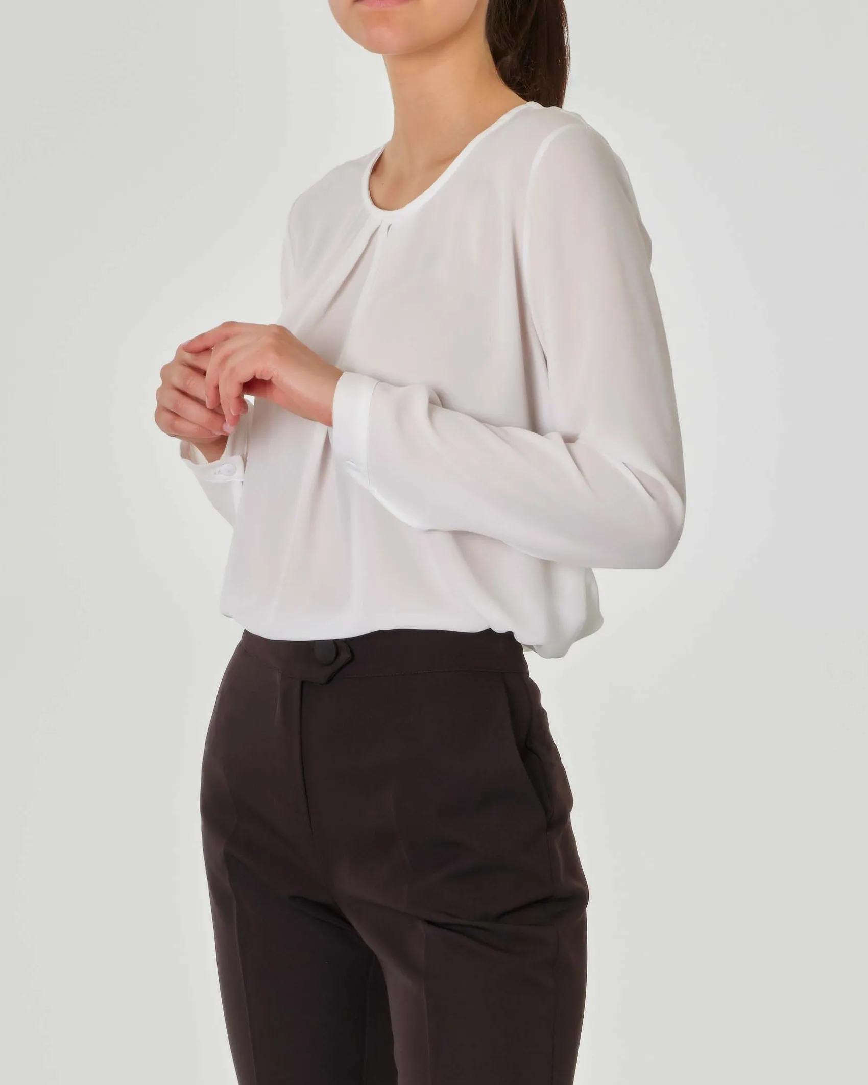 Blusa bianca con pinces sullo scollo tondo e maniche lunghe