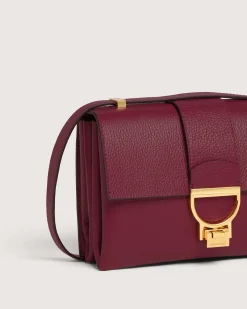 Borsa bordeaux Coccinelle Arlettis in pelle a grana grossa con patta e chiusura a battente