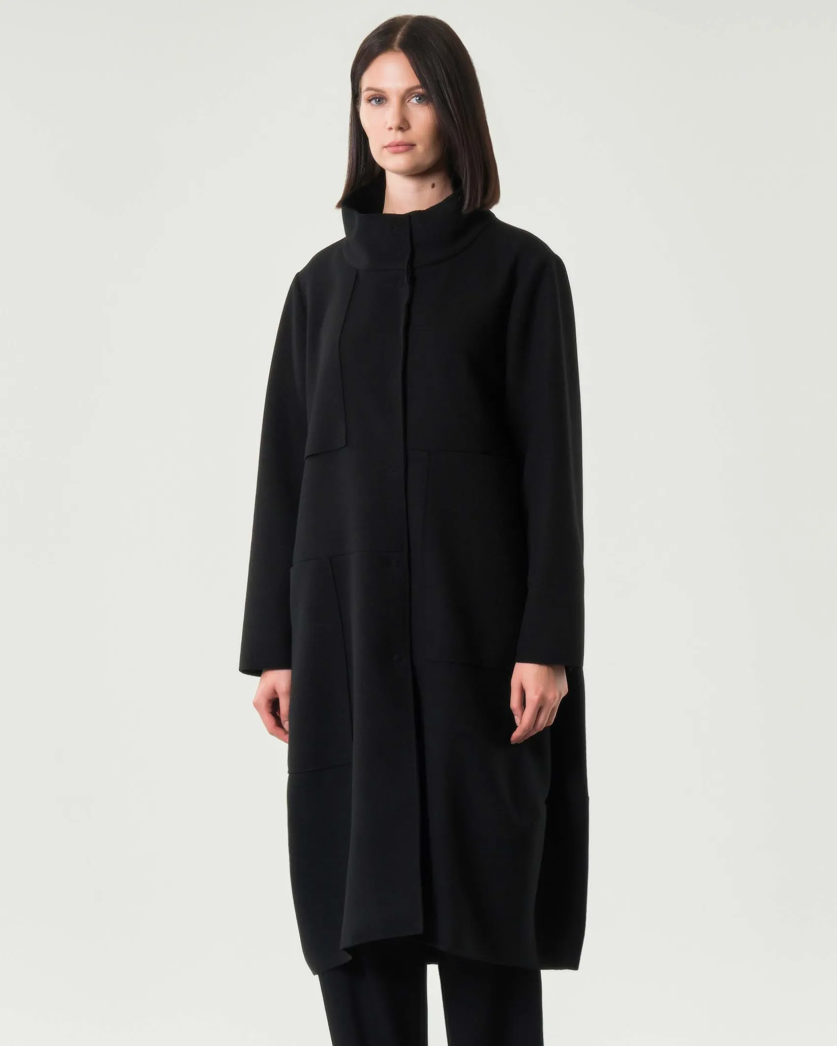 Cappotto midi nero Jurerê dalla linea a uovo in tessuto effetto panna con colletto in piedi e maxi tasche laterali applicate