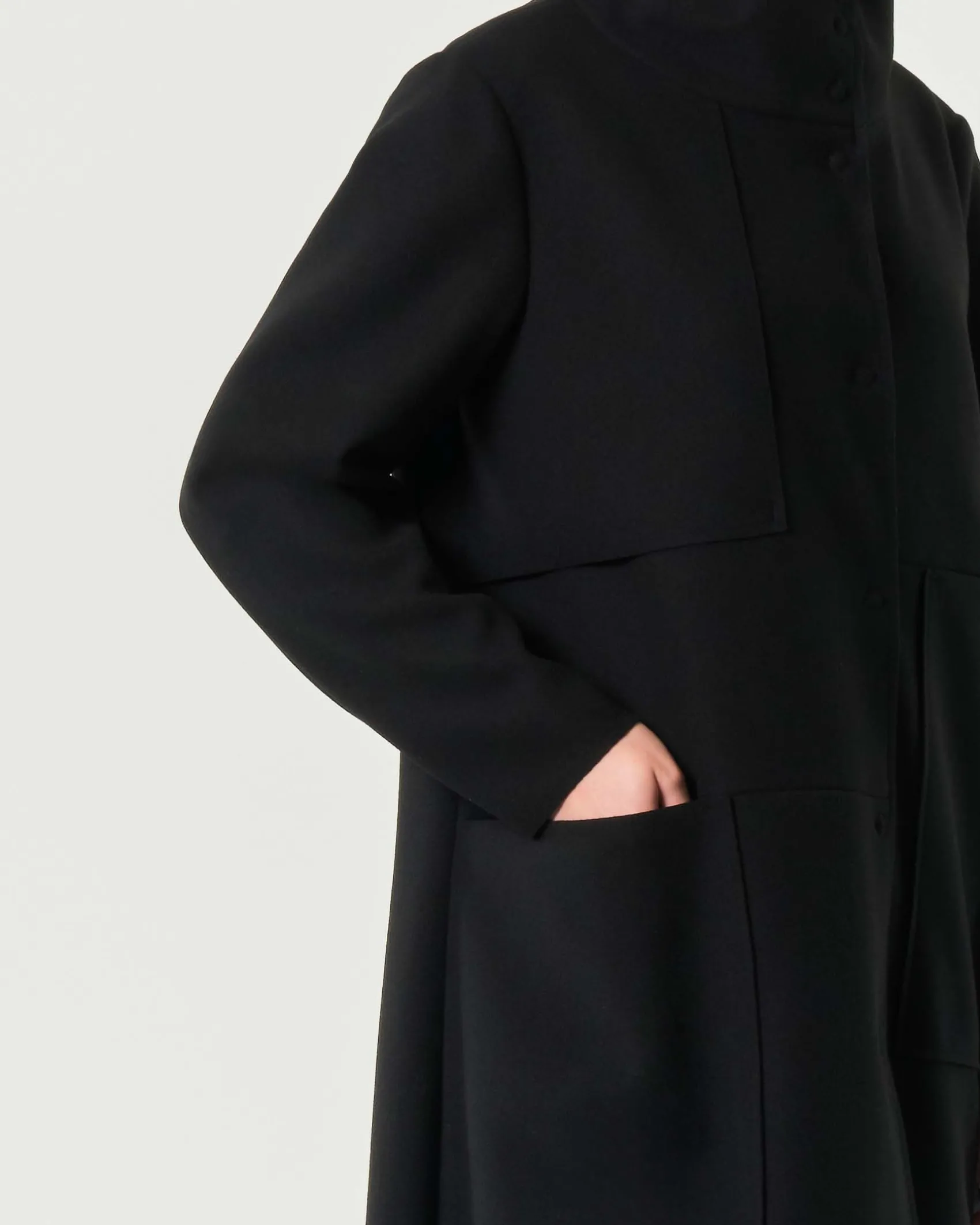 Cappotto midi nero Jurerê dalla linea a uovo in tessuto effetto panna con colletto in piedi e maxi tasche laterali applicate