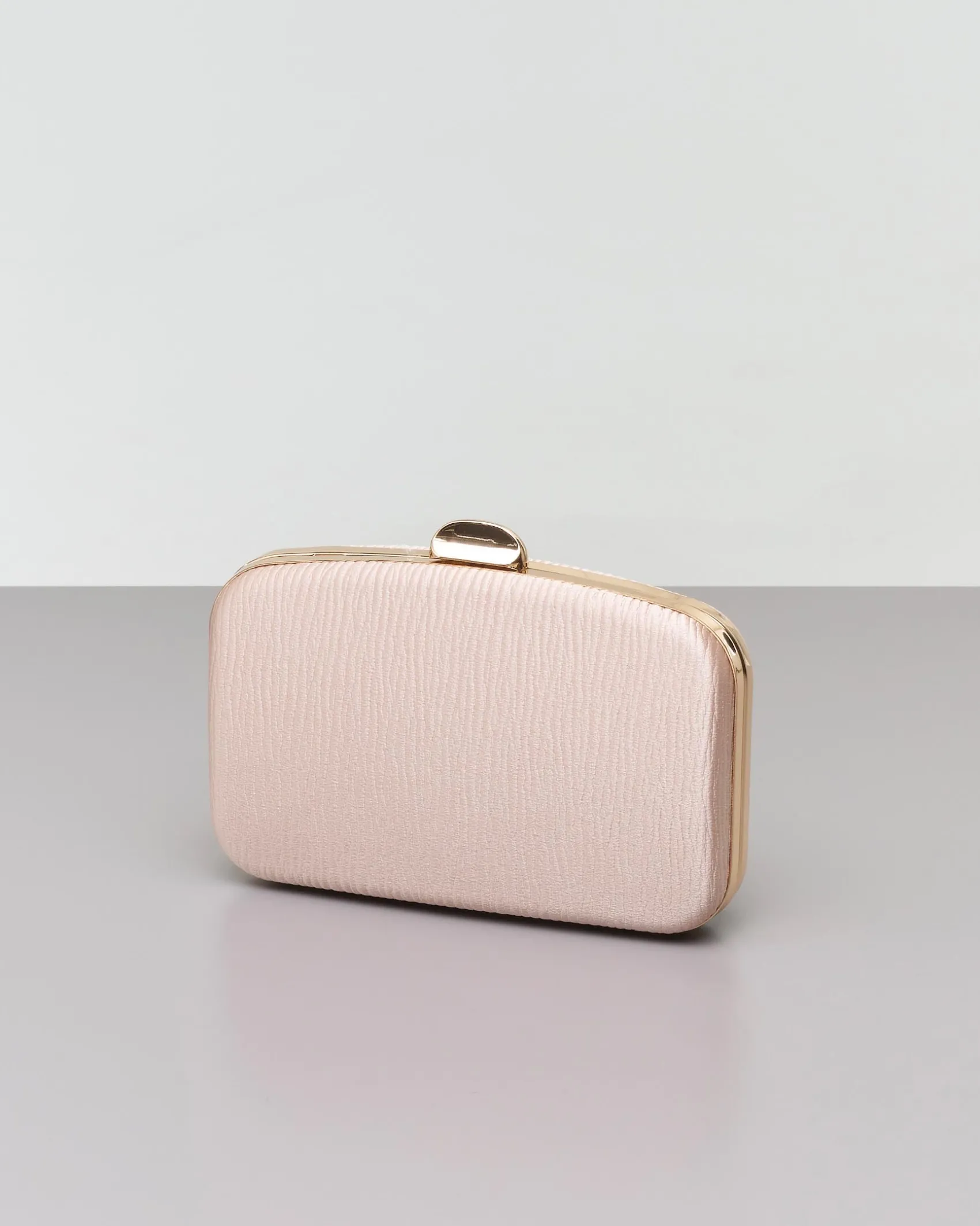 Clutch rigida color champagne in tessuto goffrato con profili e chiusura scatto in metallo dorato