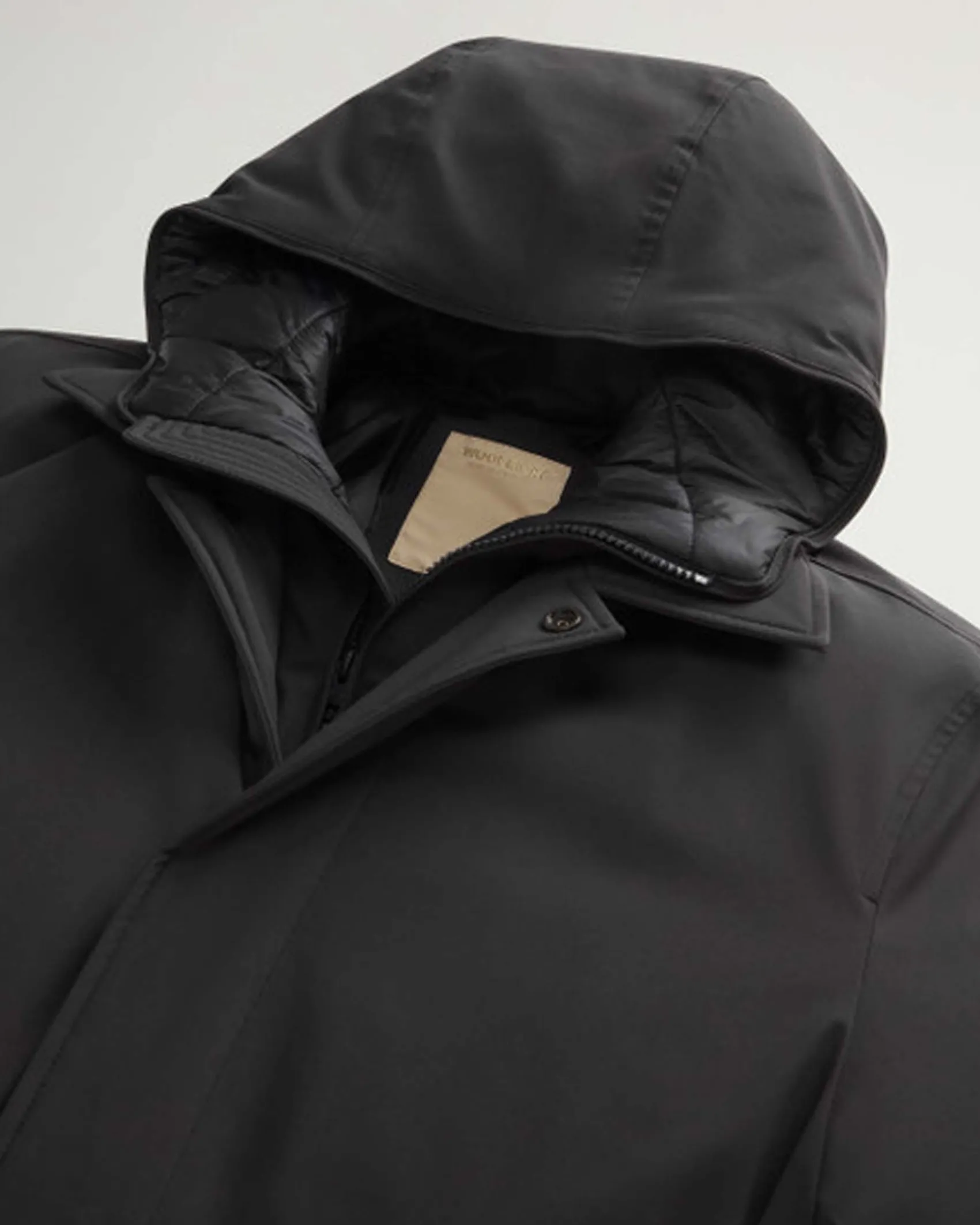 Impermeabile nero Woolrich in tessuto stretch con davantino e cappuccio staccabili